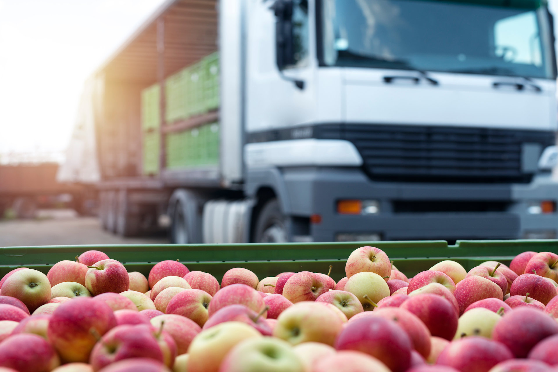 a shot of apples in front of a commercial truck